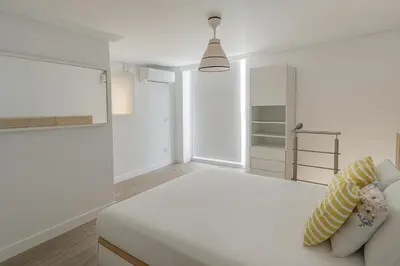 a white room with a bed and a tv at Atico duplex con Terraza en pleno centro de Jerez in Jerez de la Frontera