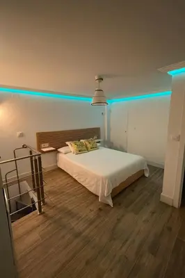 a bedroom with a bed with blue lights on it at Atico duplex con Terraza en pleno centro de Jerez in Jerez de la Frontera