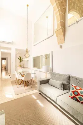a living room with a couch and a table at La Casa de los Arcos - Casco Histórico - Parking opcional in Jerez de la Frontera