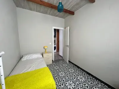 a bedroom with a bed and a yellow blanket at CASITA CÉNTRICA Corro de Bolos in Sanlúcar de Barrameda