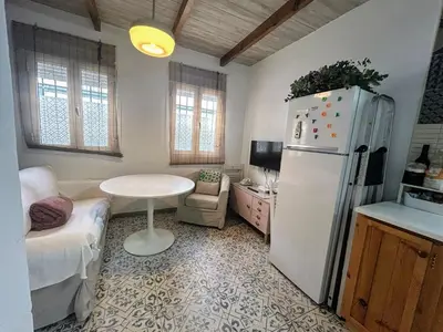 a kitchen with a white refrigerator and a table at CASITA CÉNTRICA Corro de Bolos in Sanlúcar de Barrameda