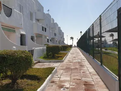 a sidewalk next to a fence next to a building at Pinar de Don Jesus Aries in Novo Sancti Petri