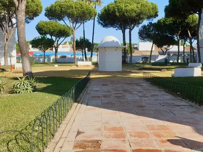 a walkway in a park next to a fence at Pinar de Don Jesus Aries in Novo Sancti Petri