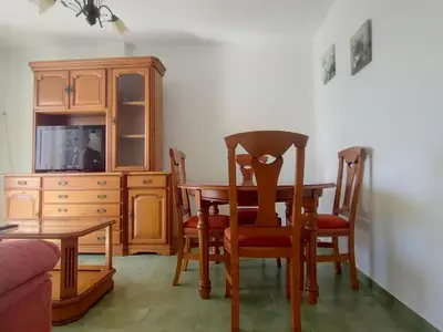 a dining room with a table and chairs and a cabinet at Pinar de Don Jesus Aries in Novo Sancti Petri