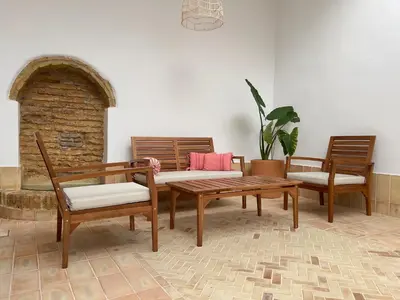 a living room with two chairs and a wooden table at Plateros 48 Apartamento in Sanlúcar de Barrameda