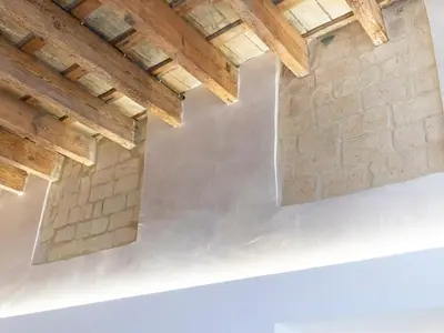 a room with wooden ceilings and a brick wall at Plateros 48 Apartamento in Sanlúcar de Barrameda
