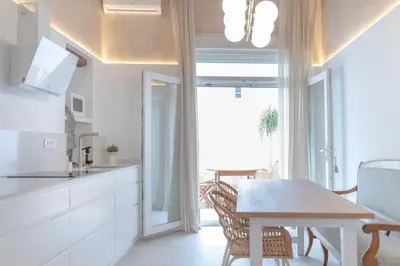 a kitchen and dining room with a table and chairs at Plateros 48 Apartamento in Sanlúcar de Barrameda