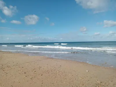 a sandy beach with waves in the ocean at Apartamento Mar I in San Fernando