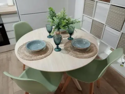 a dining room table with plates and bowls and green chairs at Apartamento Mar I in San Fernando