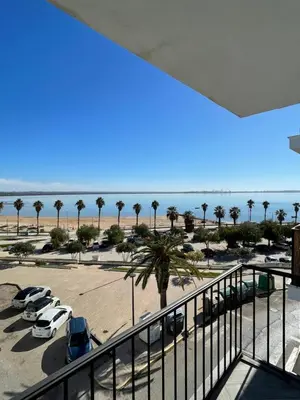 a view of a parking lot with palm trees and the ocean at Piso playa Maktub in Puerto Real