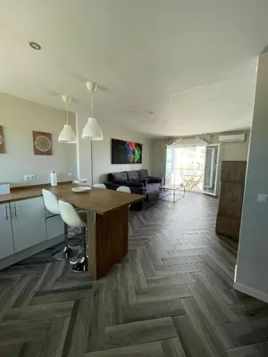 a kitchen and living room with a table and a couch at Piso playa Maktub in Puerto Real