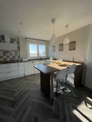 a large kitchen with a large wooden table and chairs at Piso playa Maktub in Puerto Real