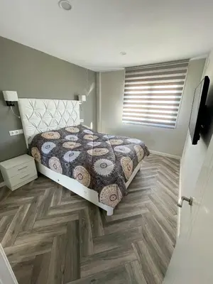 a bedroom with a bed and a wooden floor at Piso playa Maktub in Puerto Real