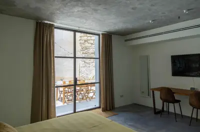 a bedroom with a bed and a desk and a window at La Bodega Flamenca in Jerez de la Frontera