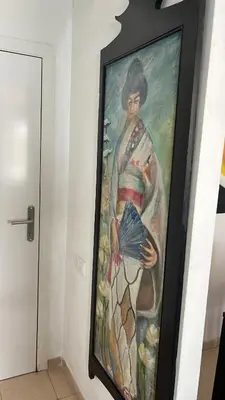 a painting of a woman holding an umbrella on a wall at Quito in El Puerto de Santa María