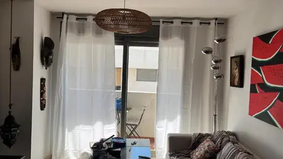 a living room with a window with white curtains at Quito in El Puerto de Santa María