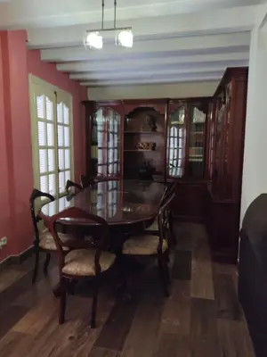 a dining room with a wooden table and chairs at Casa Hormaza in Chiclana de la Frontera