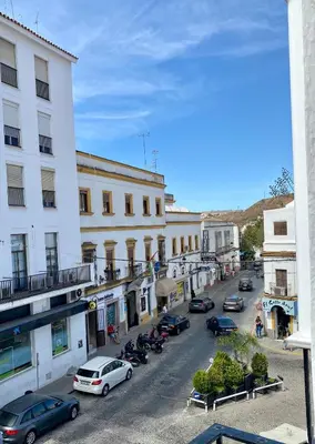 a city street with cars parked in front of buildings at CasaElbarranko in Arcos de la Frontera