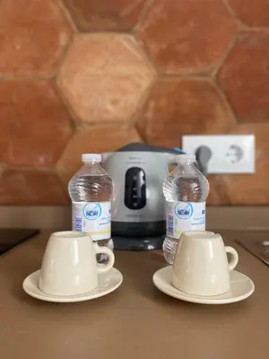 two bottles of water and two cups on a counter at CasaElbarranko in Arcos de la Frontera