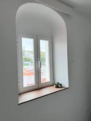 a mirror in a white room with a window at CasaElbarranko in Arcos de la Frontera