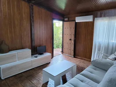 a living room with a couch and a tv at Bungalow para quienes buscan tranquilidad in Chiclana de la Frontera