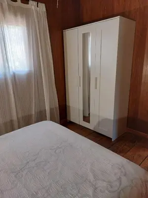 a bedroom with a white cabinet and a bed at Bungalow para quienes buscan tranquilidad in Chiclana de la Frontera