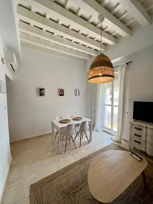 a white dining room with a table and chairs at La Roca del Sur by Cadiz Time in Cádiz