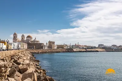 a body of water with a city in the background at La Roca del Sur by Cadiz Time in Cádiz