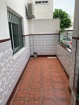 a balcony of a house with a red tile floor at Casa Amapola - Costa Bahía de Cádiz in Puerto Real