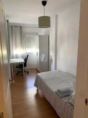 a white bedroom with a bed and a desk at Casa Amapola - Costa Bahía de Cádiz in Puerto Real