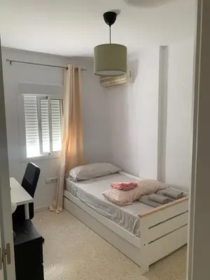 a bedroom with a bed and a desk and a window at Casa Amapola - Costa Bahía de Cádiz in Puerto Real