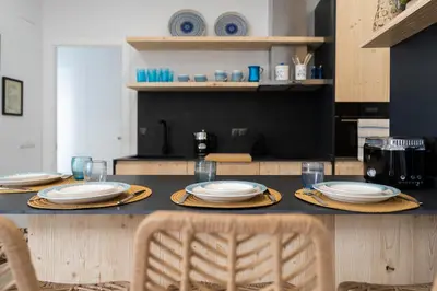 a table with plates and glasses on it in a kitchen at Mistral playa la caleta Ascensor Grupo AC Gestion in Cádiz