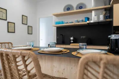 a table with two chairs and plates on it at Mistral playa la caleta Ascensor Grupo AC Gestion in Cádiz