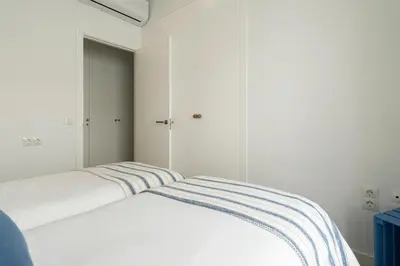 a bedroom with two white beds and a blue cabinet at Mistral playa la caleta Ascensor Grupo AC Gestion in Cádiz