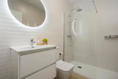 a bathroom with a sink and a toilet and a mirror at Mistral playa la caleta Ascensor Grupo AC Gestion in Cádiz