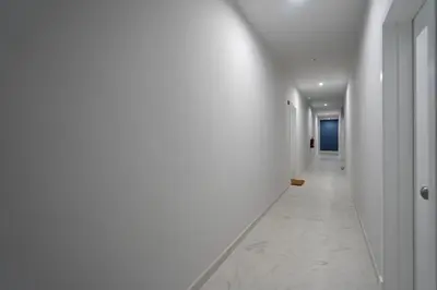 a hallway with white walls and a white tile floor at Mistral playa la caleta Ascensor Grupo AC Gestion in Cádiz
