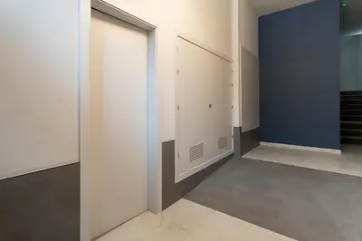 a hallway with white doors and a blue wall at Mistral playa la caleta Ascensor Grupo AC Gestion in Cádiz