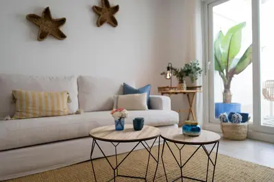a living room with two tables in front of a couch at Mistral playa la caleta Ascensor Grupo AC Gestion in Cádiz
