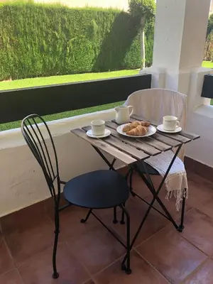 a table and chairs with a plate of food on it at Playa Laguna Bajo Parking in Chipiona