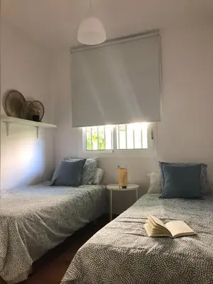 a bedroom with two beds with a book on them at Playa Laguna Bajo Parking in Chipiona