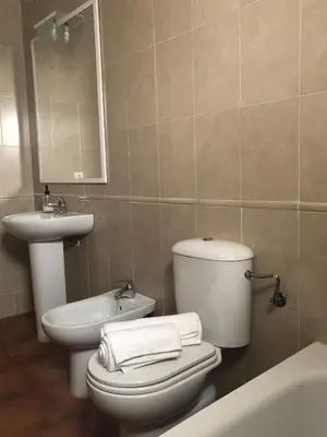 a bathroom with a toilet and a sink and a mirror at Playa Laguna Bajo Parking in Chipiona