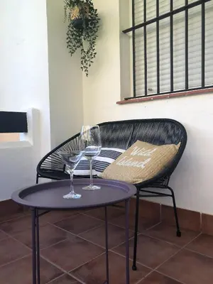 two wine glasses on a table next to a chair at Playa Laguna Bajo Parking in Chipiona