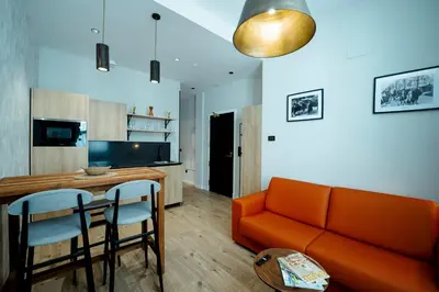 a kitchen and living room with a table and chairs at Aparthotel Luz de Gades - Suites Spa Gym - Adults Only in Cádiz