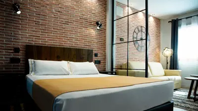 a room with a table with a plate of food and a clock at Aparthotel Luz de Gades - Suites Spa Gym - Adults Only in Cádiz