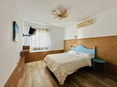 a bedroom with a blue bed and a ceiling fan at La Casita del Mar in El Puerto de Santa María