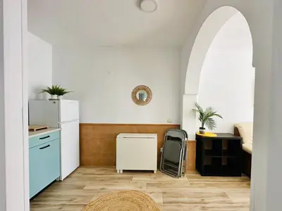 a kitchen with a white refrigerator and a table at La Casita del Mar in El Puerto de Santa María