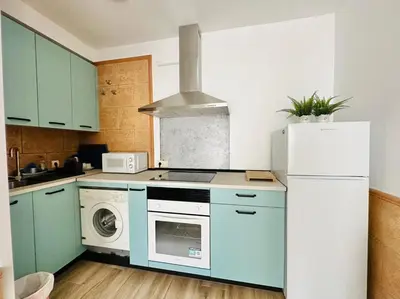 a kitchen with blue cabinets and a white refrigerator at La Casita del Mar in El Puerto de Santa María