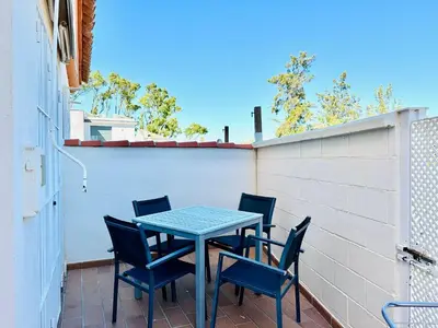 a table and chairs on a patio with a fence at La Casita del Mar in El Puerto de Santa María