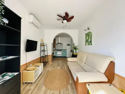 a living room with a couch and a ceiling fan at La Casita del Mar in El Puerto de Santa María