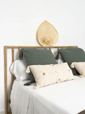 a bed with white sheets and green pillows at Apartamento Mucha Vida Little Apartments in Cádiz